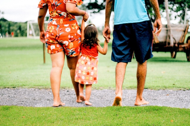 A view from behind of two adults and a child walking together