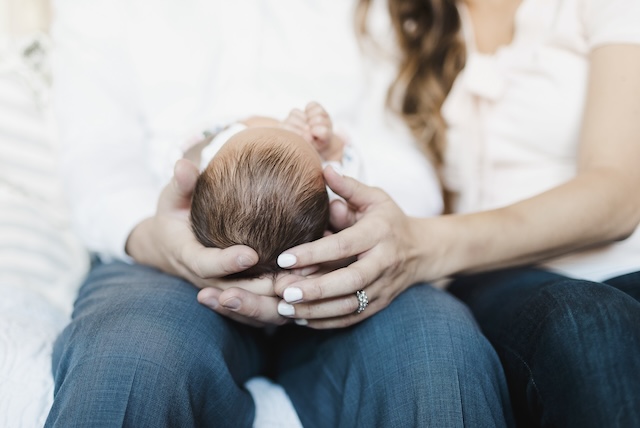 An infant being held on a lap