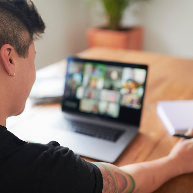 An image of a person looking at a blurred laptop screen