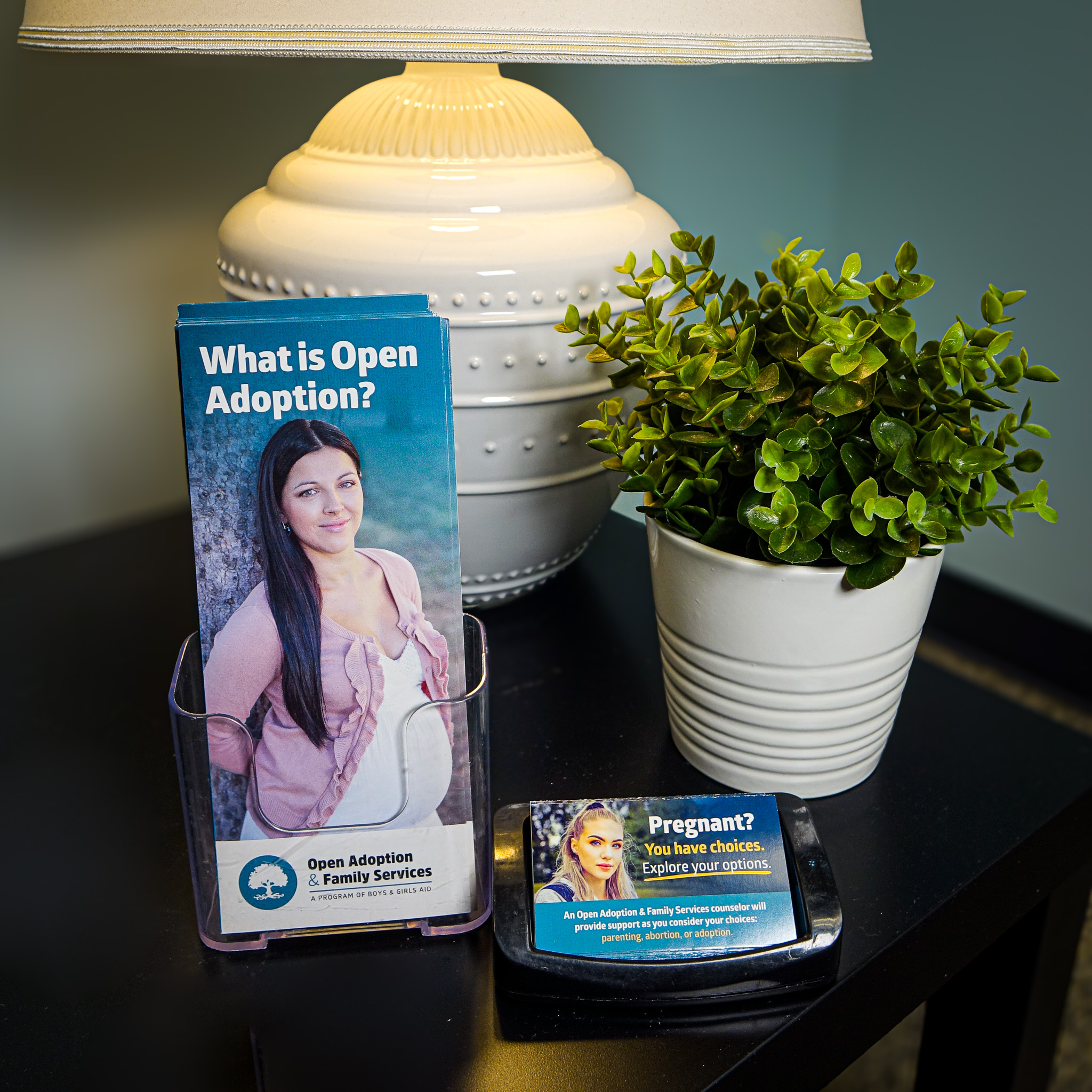 An image of a table with a lamp and brochures
